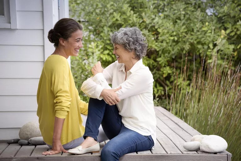 happy-mother-talking-with-her-adult-daughter-on-porch-667601035-589587625f9b5874eec49b08